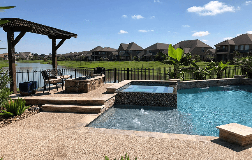 Backyard pool with patio and lake view.
